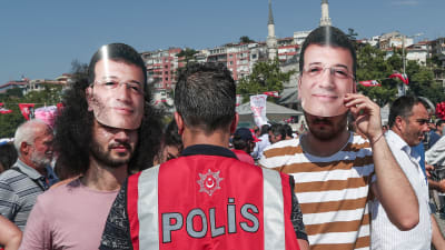 Anhängare till Ekrem Imamoglu i masker som föreställer honom under lördagens valmöte.