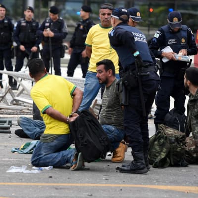 Poliisit pidättämässä mielenosoittajia kadulla Brasiliassa.