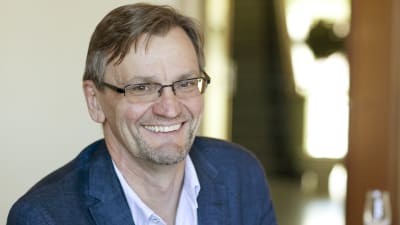 Professorn i internmedicin vid Helsingfors universitet Per-Henrik Groop leende i blå kavaj.