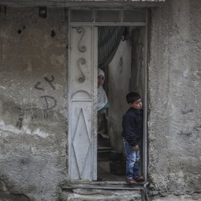 Syriska barnen Yasser och Heba tittar ut från sitt hem i Damaskus i Syrien 22 februari 2016.