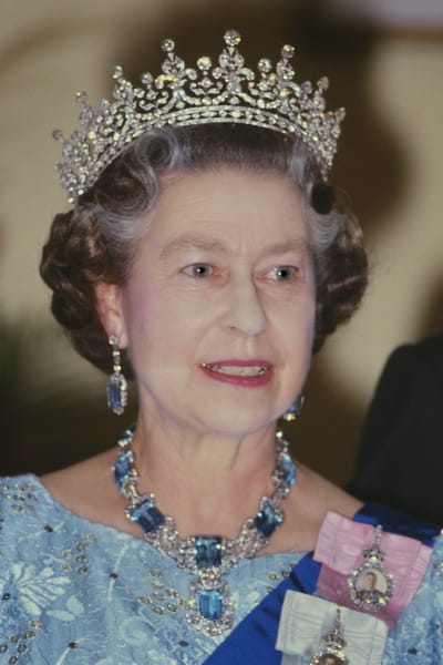 En gammal bild på en ung drottning Elizabeth i krona och finklänning.