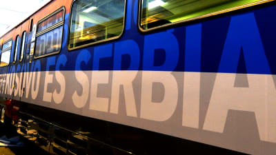 Kosovo är Serbien skrivet på en tågvagn på spanska, på en bakgrund i den serbiska flaggans färger.