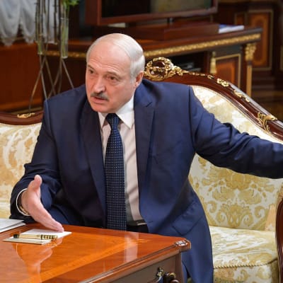 Aljaksandr Lukashenka istumassa sohvalla.