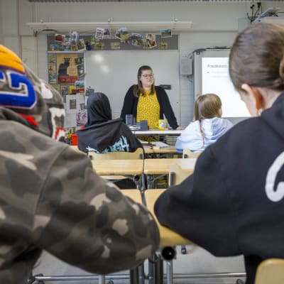 oppilaat seuraavat luokan edessä olevaa opettjaa.