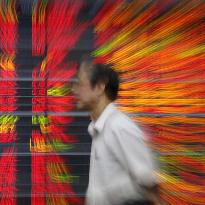 Thailändsk investerare passerar en elektronisk tavla som visar fallande börskurser 07012016