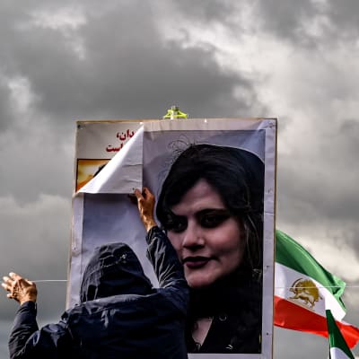 Bild på Mahsa Amini och iransk flagga.