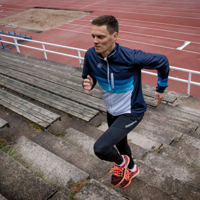 Tuomo Salonen verryttelee Otaniemen urheilukentän portaissa
