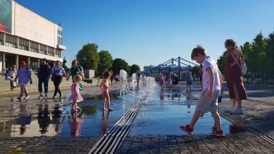 Sommarvärmen lockar ut stadsborna i Moskva. Här leker barn vid små fontäner.
