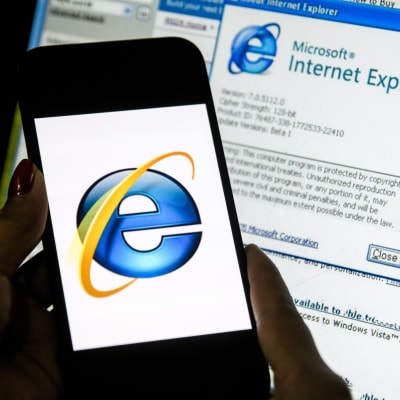 Internet Explorer -verkkoselain kuvituskuvituskuvassa tietokoneen näytöllä. Edessä puhelin, jossa selaimen logo.