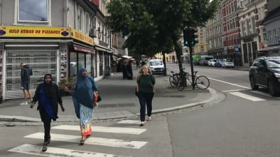 Två kvinnor i hijab går över gatan i Oslo.