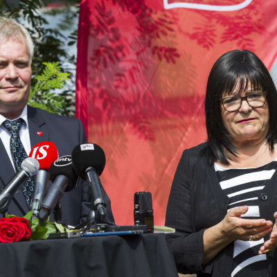 Antti Rinne och Maria Tolppanen vid ett bord med mikrofoner.