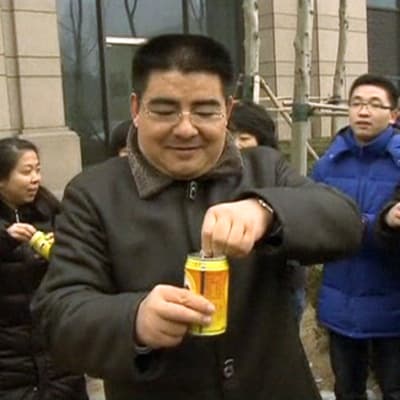 Pullotettua puhdasta ilmaa myyvä Chen Guangbiao ja hänen asiakkaitaan avaamassa pullotettua ilmaa sisältäviä tölkkejä.