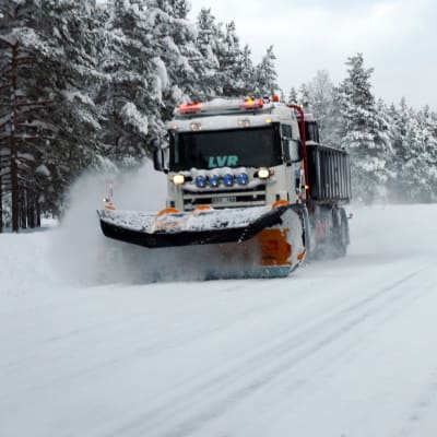 En plogbil på en snöig landsväg.