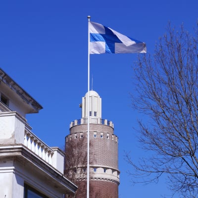 Flaggan vajar mot klarblå himmel.