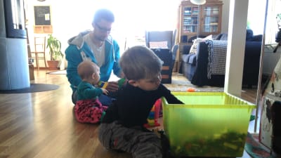 Marcus Jungersten (i bakgrunden) bygger lego med sina barn Elvina och Ebbe.
