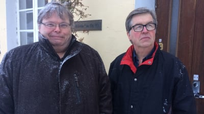 Två män utanför en kontorsbyggnad.