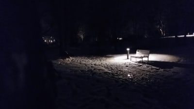 en ensam parkbänk i mörkret