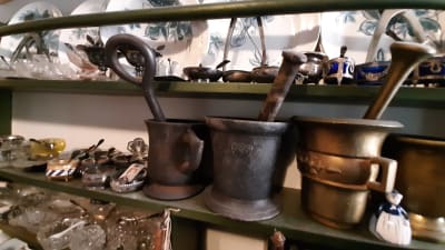 gammalt husgeråd  i metall, porslin, glas och silver på hylla i kök