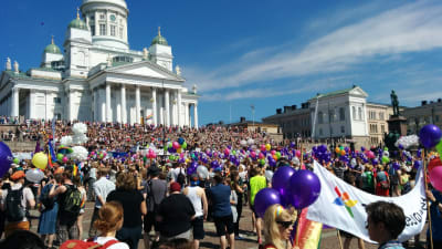 Senatstorget vimlar av pridedeltagare pch ballonger i olika färger under Helsingfors pride 2016.