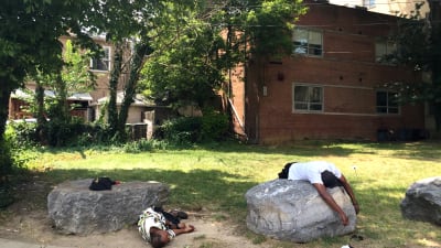 Två hemlösa sover under en het eftermiddag i Washington DC, USA.