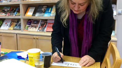 Katarina Norling skriver ordet "språk" på en lapp.