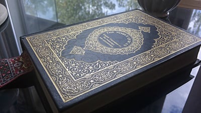 Koranen i engelsk tappning på ett glasbord