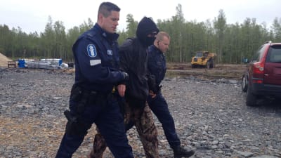 Aktivist förs bort av polis.