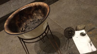 Palmkvister bränns i en skål för att bereda askan för askkorset
