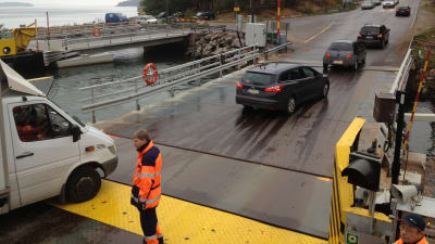 Färjkarl på landsvägsfärjan Sterna övervakar bilarna som kör av färjan i Lillmälö på Pargassidan.