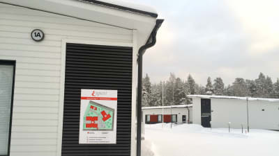 Vi trä byggnad med skylt där det står Esperi. I bakgrunden flera andra byggnader.