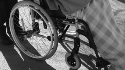Svartvit bild på dam i rullstol