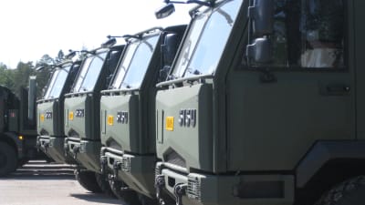 Militära Sisu-lastbilar i rad på fabrikens gårdsplan i Karis.