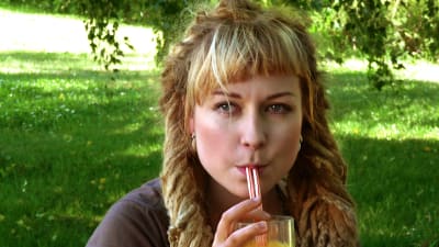 En kvinna som dricker apelsinjuice