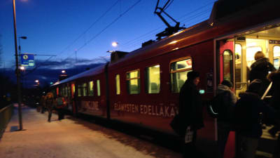 Pendlare hoppar på tåget på Sjundeå station.