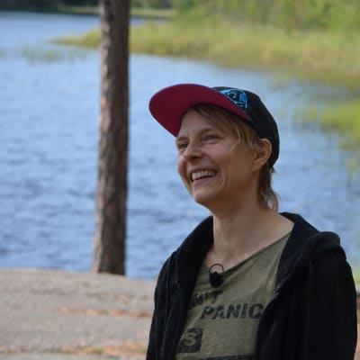 Virve Savoila med en sjö i bakgrunden. 