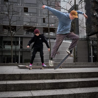 Två ungdomar åker skateboard i Kampen i Helsingfors