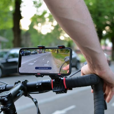 En smarttelefon på en cykelstång filmar cykelvägen framför cykeln.