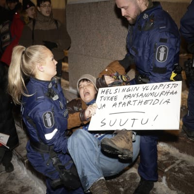 Poliisi poisti mielenosoittajan Helsingin yliopiston päärakennuksesta 29. marraskuuta 2023.