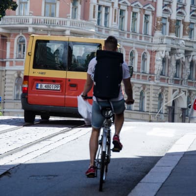 En man cyklar upp för en backe i Helsingfors.