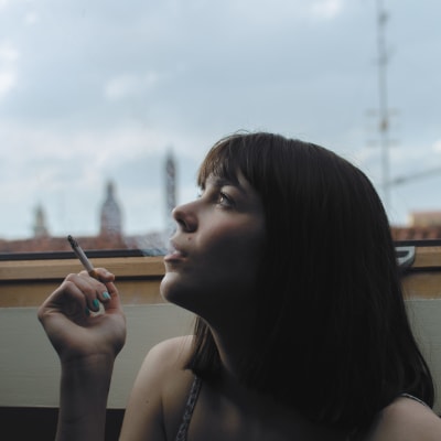 Kvinna röker på takterass