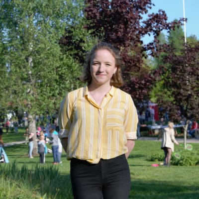 Cecilia Andersin står i en park i Grankulla, kleendes och vänd mot kameran