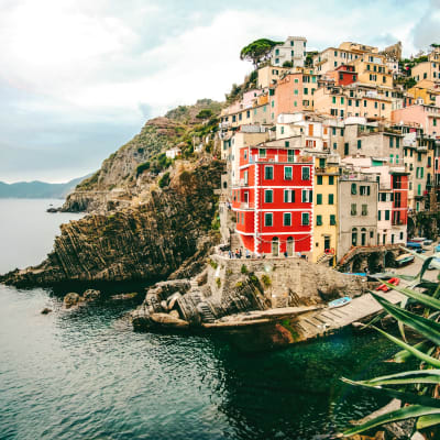 Värikkäitä pieniä taloja vuoriston rinteellä italialaisessa Riomaggioren kylässä Genovanlahden rannikolla.