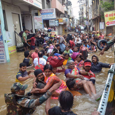 Människor i vatten efter jordskred i Kerala, Indien.
