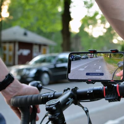 En smarttelefon på en cykelstång filmar cykelvägen framför cykeln.