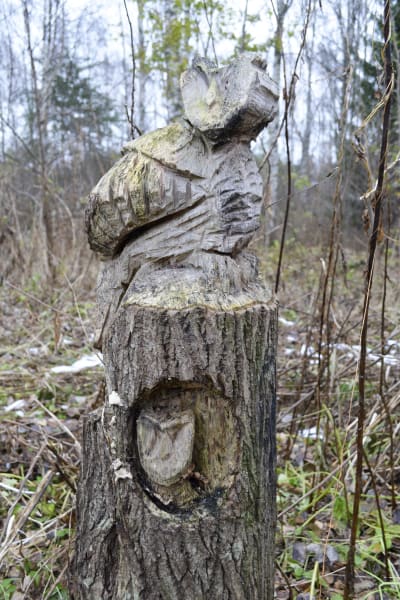 en uggla och en uggleunge har skulpterats i en stubbe med motorsåg