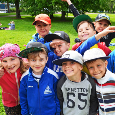 En grupp glada barn i en park. 