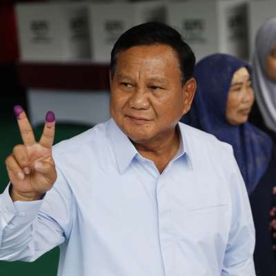 Prabowo Subianto visar att han har röstat genom att visa sina färgade fingerspetsar.