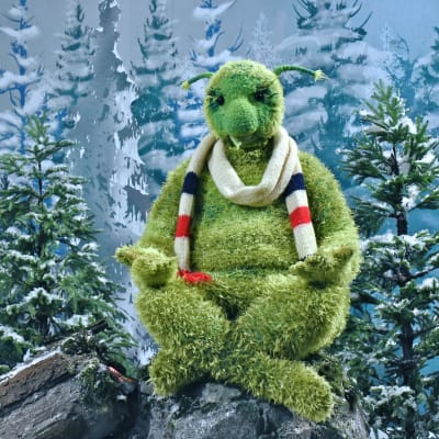 Karaktären Kusel ur tv-serien Jul i Hittehatt mediterar på en sten