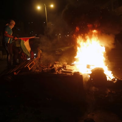 Palestinier tänder eld på en israelisk bil i Nablus efter sammandrabbningen vid Josefs grav på Västbanken.
