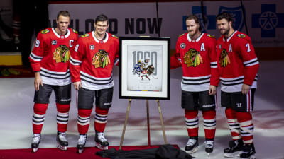 Chris Kunitz står bredvid en tavla som föreställer hans 1000 matcher i NHL.